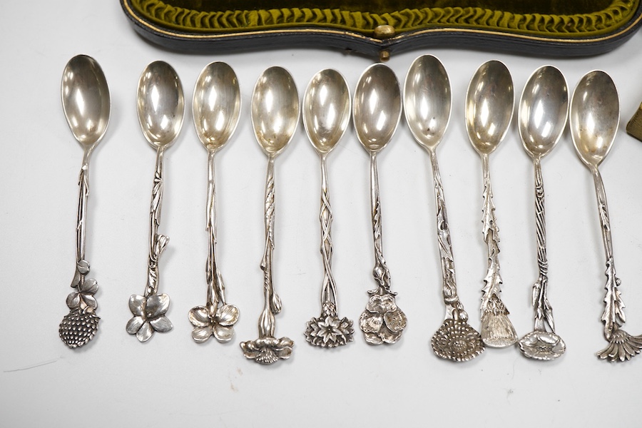 A cased set of six George V silver teaspoons and pair of sugar tongs, by Walker & Hall, Sheffield, 1918, together with a set of ten sterling coffee spoons, with floral terminals, a sterling tea strainer and a boxed Eliza